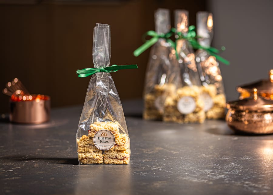 Flapjack bars individually wrapped in clear bags with ribbon ties and a branded seal